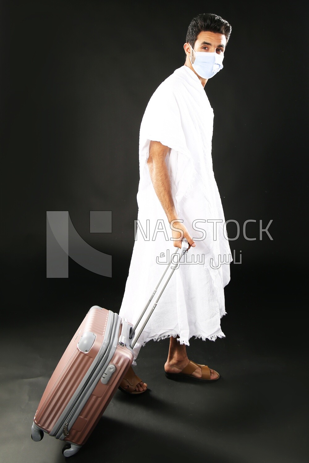 A man wearing an ihram dress with his luggage