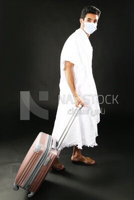A man wearing an ihram dress with his luggage