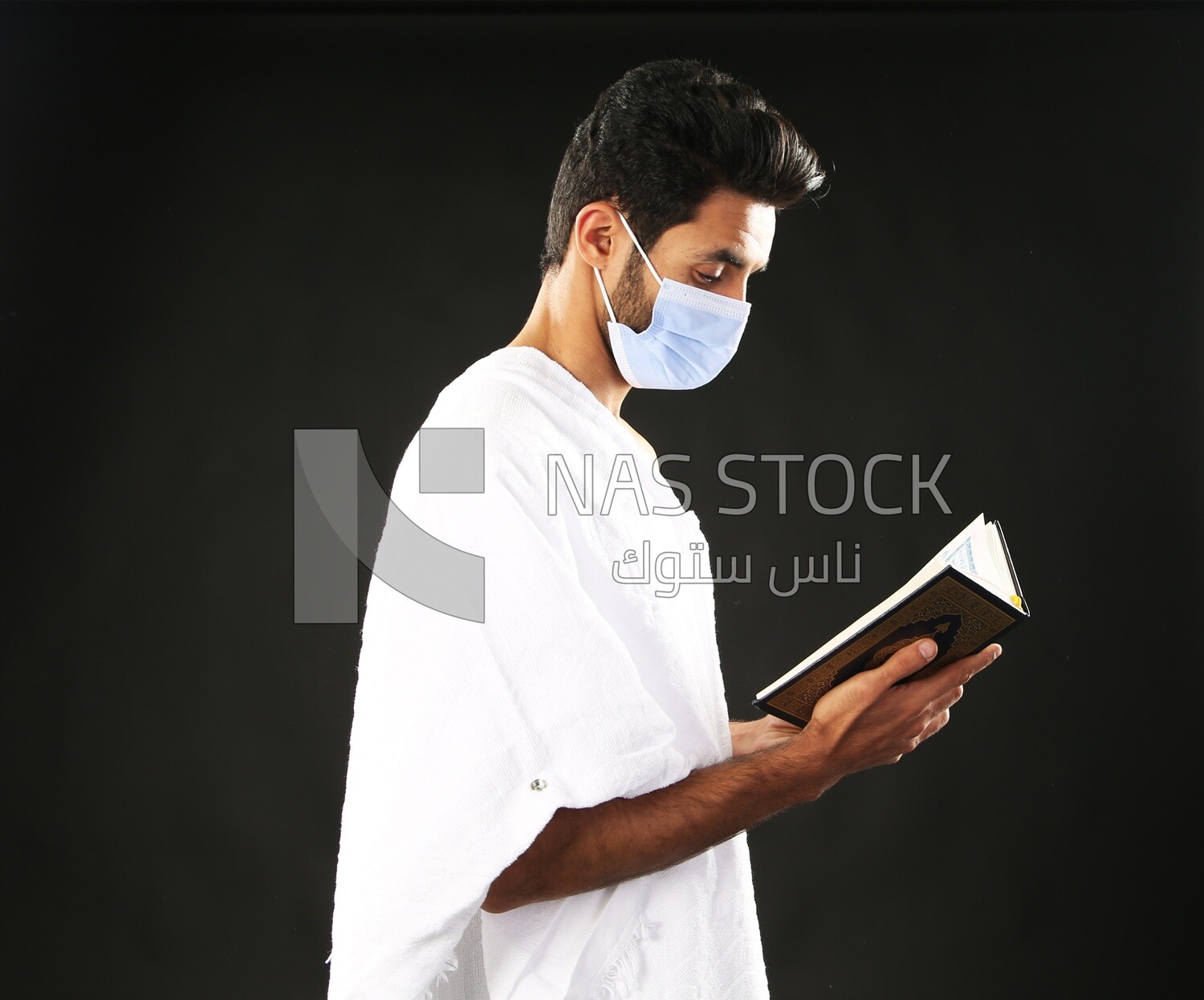 A man wearing an ihram dress prays