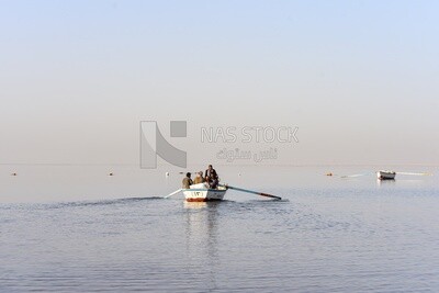 Group of men sailing a wooden boat in the lake
