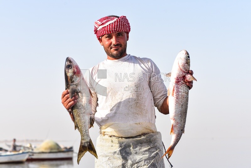 Egyptian fisherman holding fresh fish