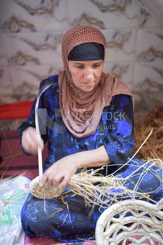 Egyptian woman making wicker decorations for the house