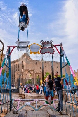 Children&#39;s playing in a swing at Eid, street, festival