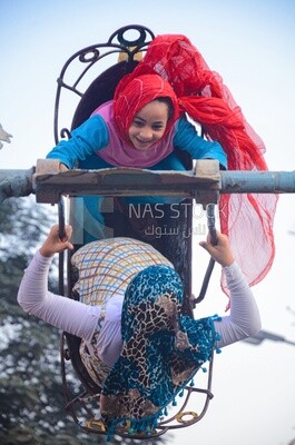 Children&#39;s playing in a swing at eid, street, festival