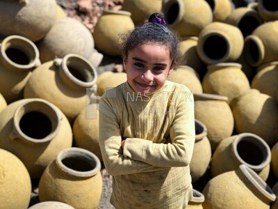 An Egyptian girl holding a pottery pot