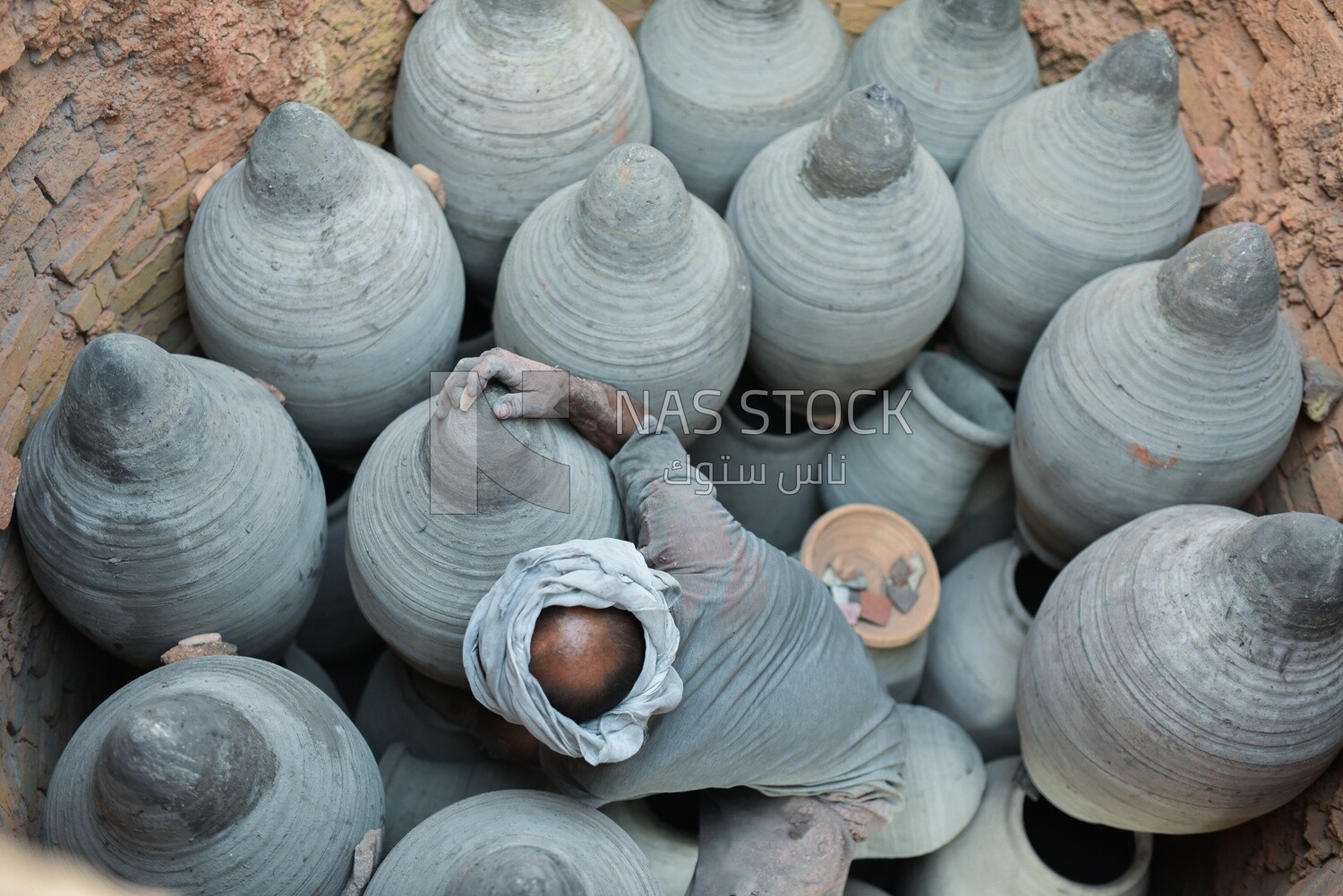 Craftsman arranges the pottery to dry, which is one of the stages of pottery making