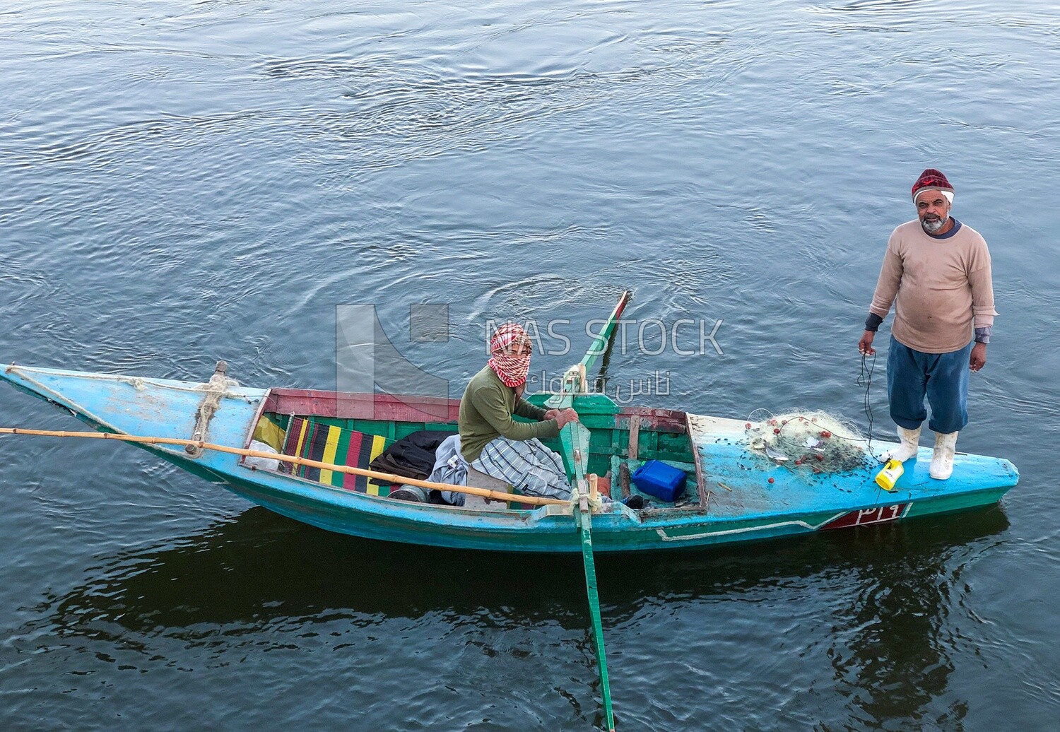 Boat with fishermen in the Nile River catching fish
