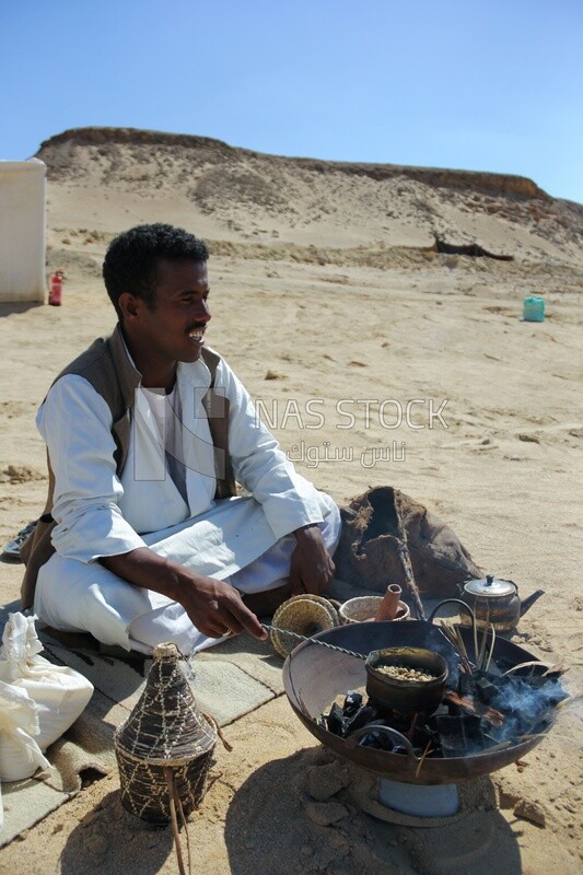 Bedouin man in the desert sitting and cooking