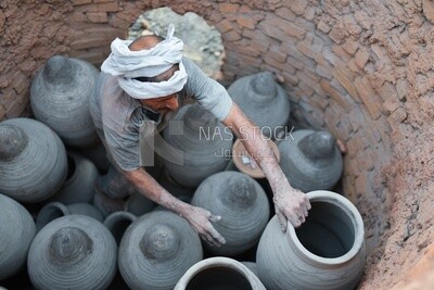 Craftsman arranges the pottery to dry, which is one of the stages of pottery making