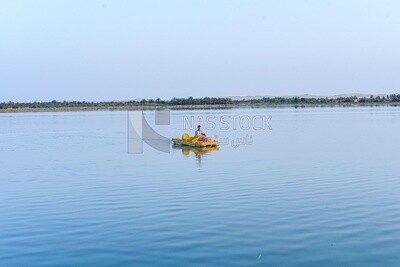 A man rides a pedalo boat in a lake in Siwa Oasis