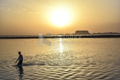 A man swimming in one of Siwa lakes at sunset