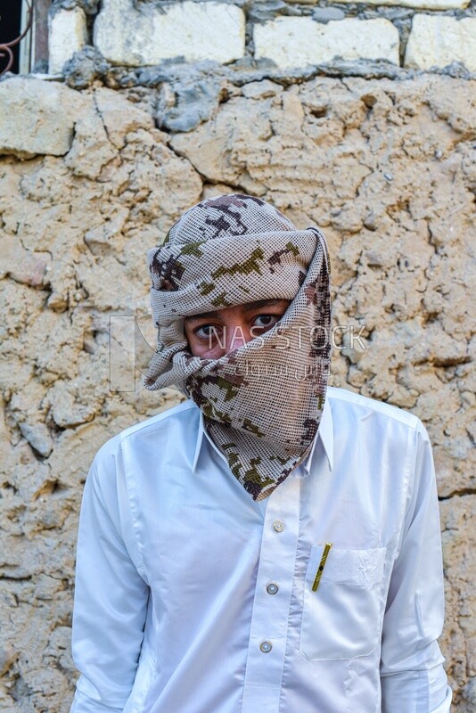 A man hides his face with an Arab scarf