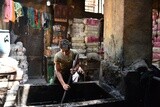 Guy dyes threads in a dyeing workshop