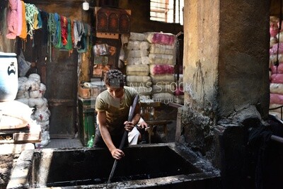 Guy dyes threads in a dyeing workshop