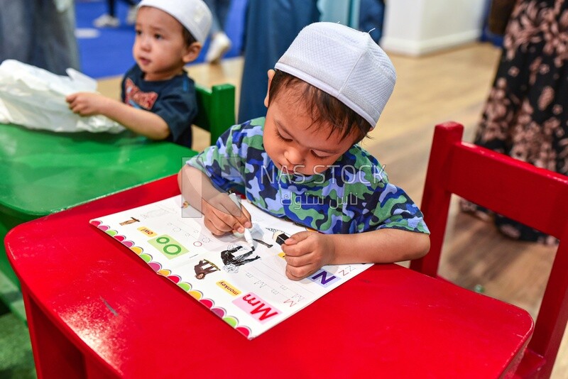 Scene of a child coloring in an educational book for children at the book fair