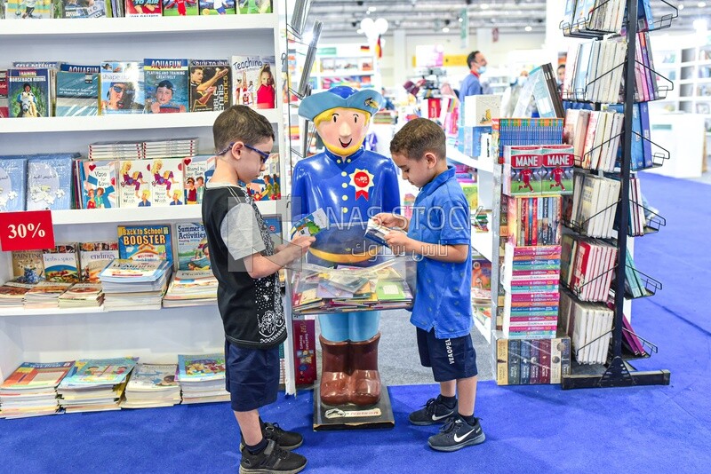Children looking at children's books for an entertaining story at the book fair