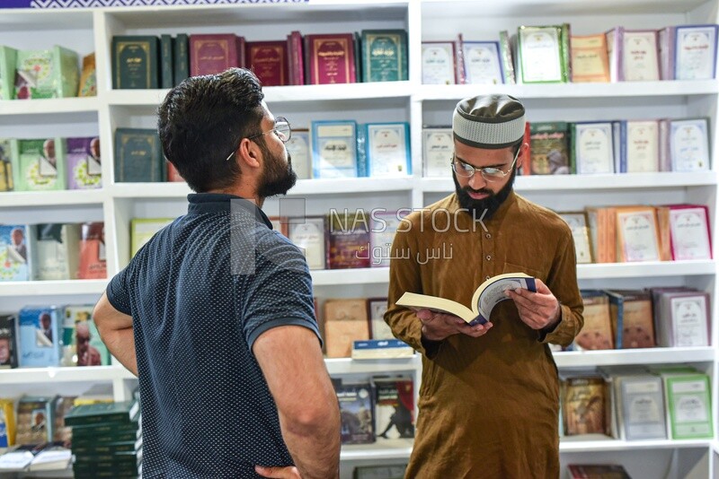 Two men browsing books at a book fair