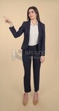 Photo of a businesswoman standing and pointing, meeting at the workplace, discussing work tasks, taking notes on the board