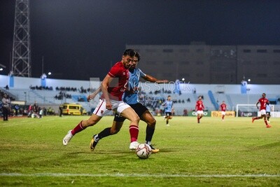 Two soccer players fighting for the ball