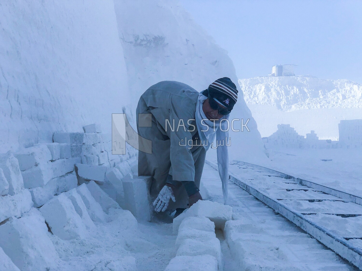 An Egyptian craftsman arranging the white bricks