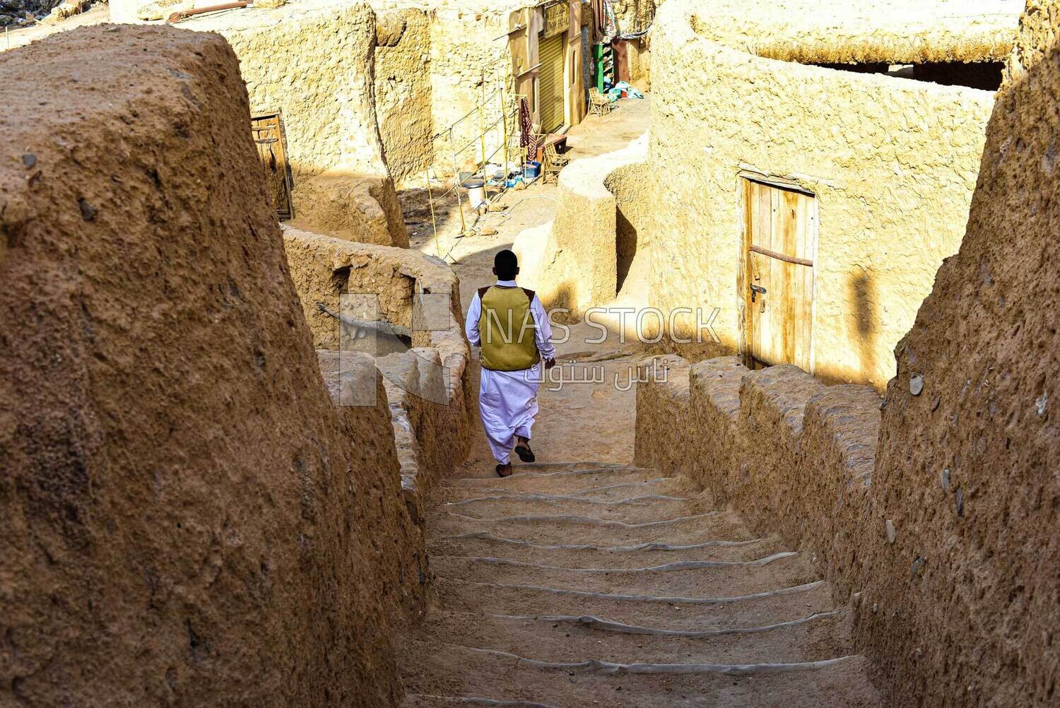 A man coming down the stairs of a house in Siwa