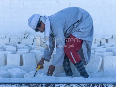 An Egyptian craftsman arranging the white bricks