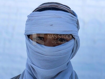 An Egyptian worker covers a face with brick dust from the brick industry