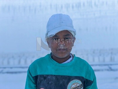 Boy works with his father in the white brick industry