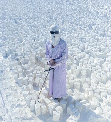 An Egyptian craftsman working in the brick industry stands on top of the white brick slabs