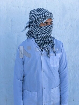 An Egyptian worker covers a face with brick dust from the brick industry