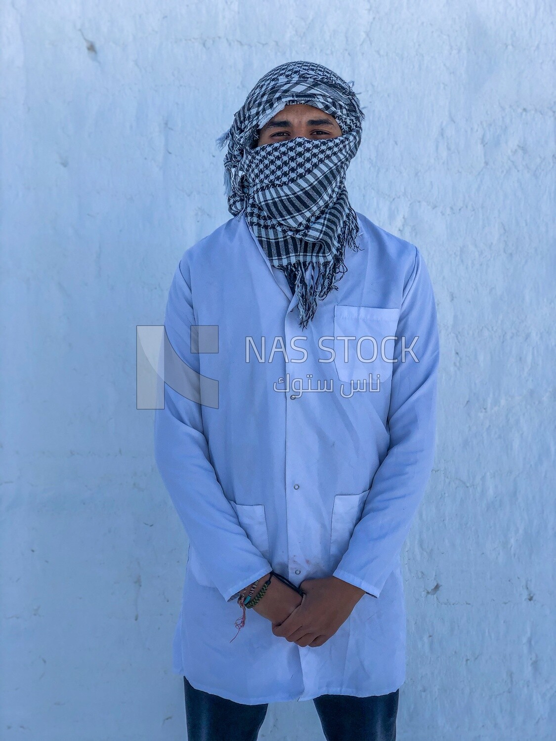An Egyptian worker stands among the mountains of white bricks and covers his face