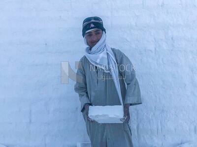 Craftsman standing and carrying white bricks