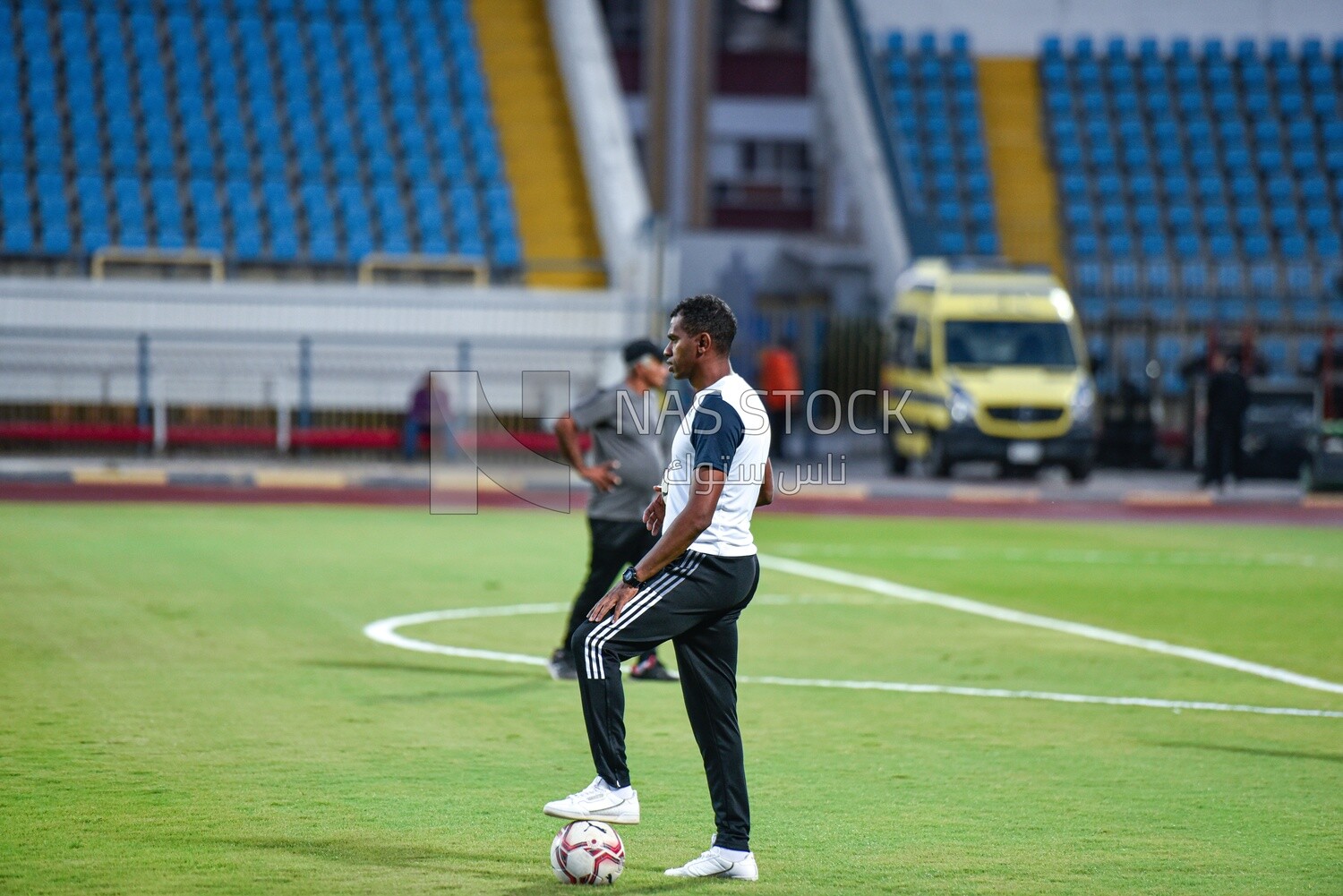 Person standing on the court carrying balls
