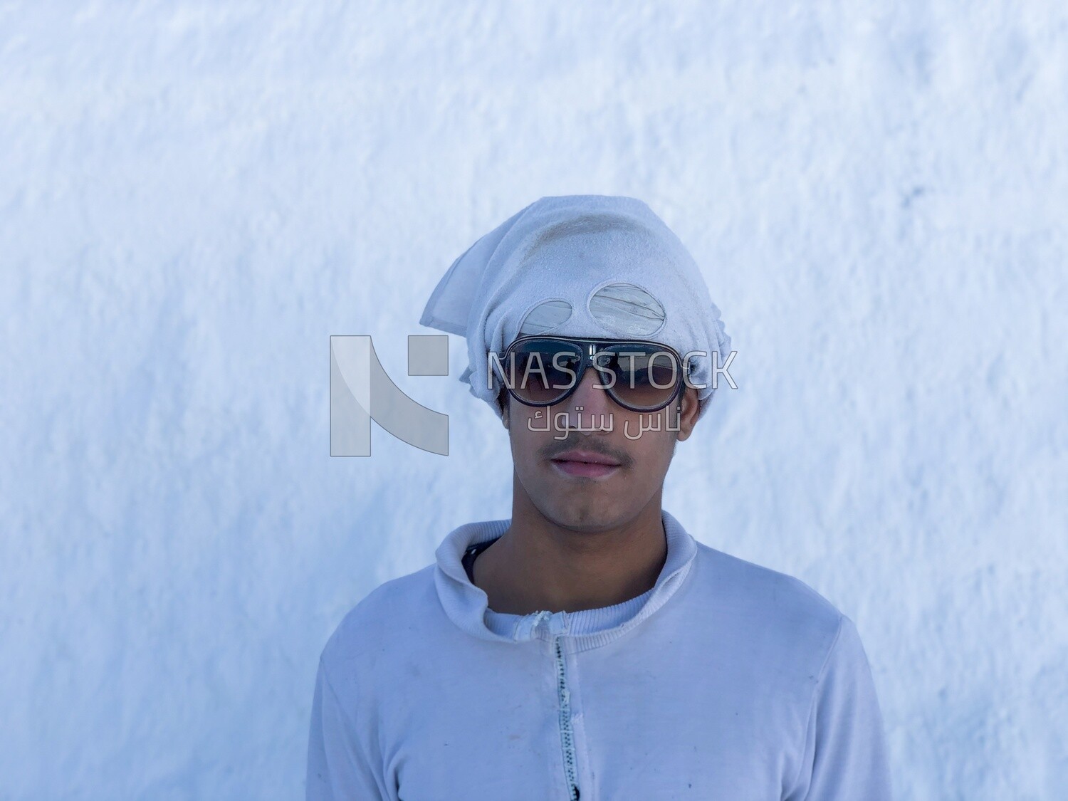 An Egyptian craftsman standing in the middle of the white brick mountains
