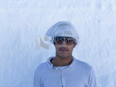 An Egyptian craftsman standing in the middle of the white brick mountains