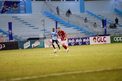 Two soccer players fighting for the ball