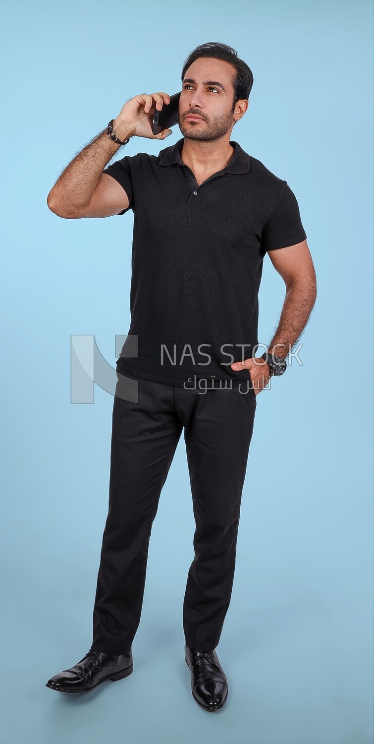 Photo Of a Handsome man Standing and talking in the mobile, Smiling Man, Wearing Casual Clothes Posing In a Light Room Interior, Smiling At the Camera