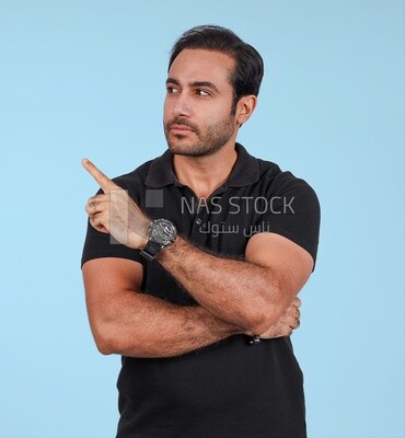 Photo Of a Handsome man Standing and pointing away, Smiling Man, Wearing Casual Clothes Posing In a Light Room Interior, Smiling At the Camera
