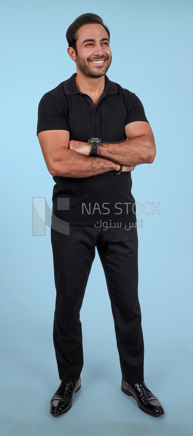 Photo Of a Handsome man Standing with crossed hands, Smiling Man, Wearing Casual Clothes Posing In a Light Room Interior, Smiling At the Camera