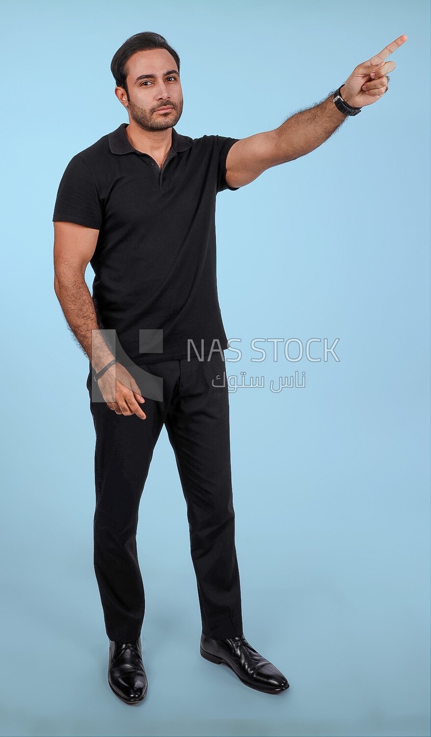 Photo Of a Handsome man Standing and pointing away, Smiling Man, Wearing Casual Clothes Posing In a Light Room Interior, Smiling At the Camera