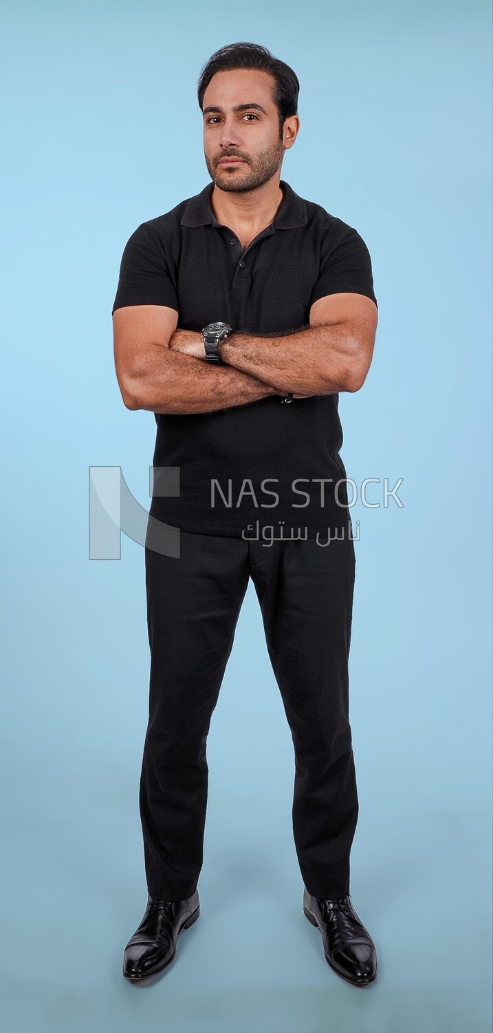 Photo Of a Handsome man Standing with crossed hands, Smiling Man, Wearing Casual Clothes Posing In a Light Room Interior, Smiling At the Camera