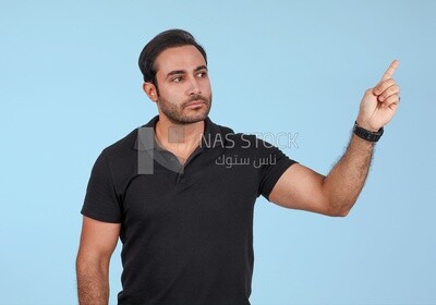Photo Of a Handsome man Standing and pointing away, Smiling Man, Wearing Casual Clothes Posing In a Light Room Interior, Smiling At the Camera