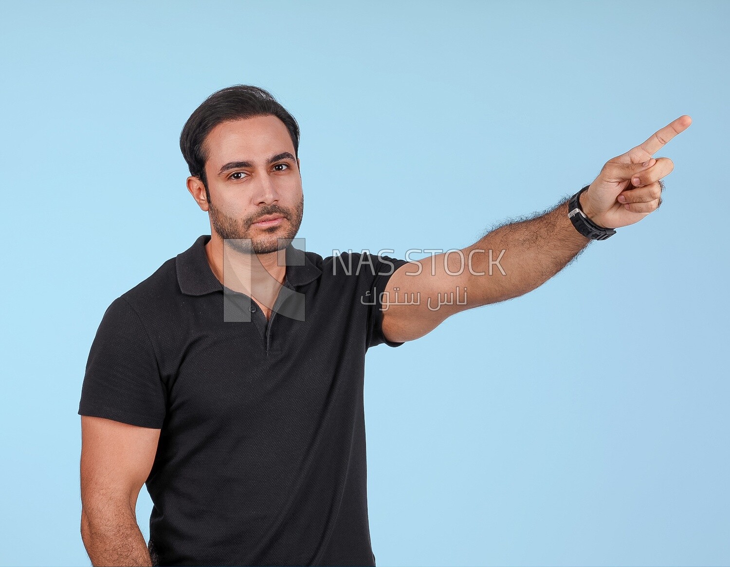 Photo Of a Handsome man Standing and pointing away, Smiling Man, Wearing Casual Clothes Posing In a Light Room Interior, Smiling At the Camera