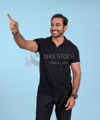 Photo Of a Handsome man Standing and pointing away, Smiling Man, Wearing Casual Clothes Posing In a Light Room Interior, Smiling At the Camera