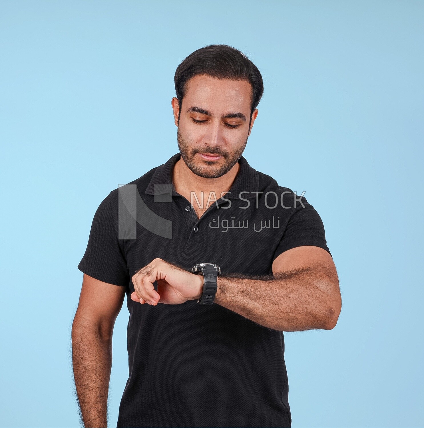 Portrait Of a Handsome man Standing and looking at his watch, Smiling Man, Wearing Casual Clothes Posing In a Light Room Interior, Smiling At the Camera