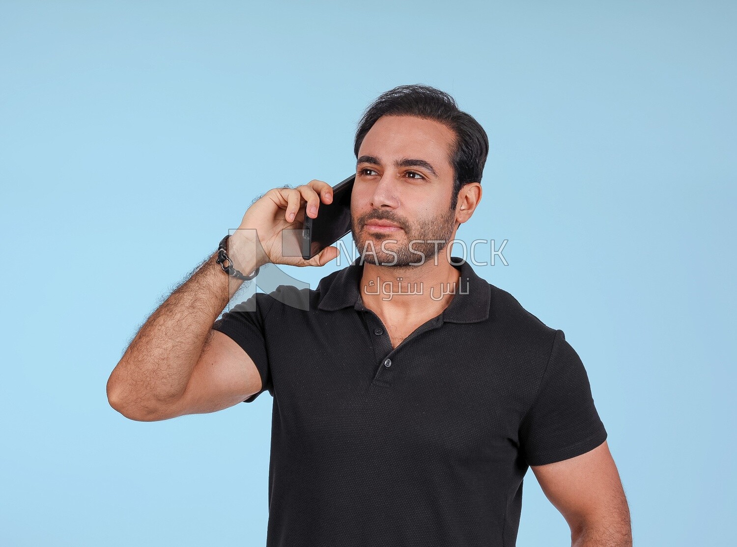 Photo Of a Handsome man Standing and talking in the mobile, Smiling Man, Wearing Casual Clothes Posing In a Light Room Interior, Smiling At the Camera