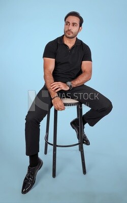 Photo Of a Handsome man sitting on the chair looks away, Smiling Man, Wearing Casual Clothes Posing In a Light Room Interior, Smiling At the Camera