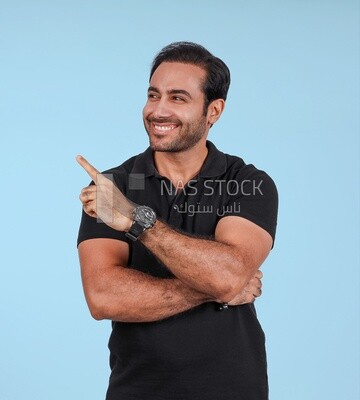 Photo Of a Handsome man Standing and pointing away, Smiling Man, Wearing Casual Clothes Posing In a Light Room Interior, Smiling At the Camera