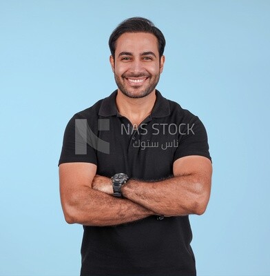 Photo Of a Handsome man Standing with crossed hands, Smiling Man, Wearing Casual Clothes Posing In a Light Room Interior, Smiling At the Camera