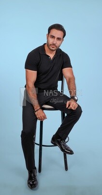 Photo Of a Handsome man sitting on the chair, Smiling Man, Wearing Casual Clothes Posing In a Light Room Interior, Smiling At the Camera